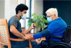 CNAs check patients blood pressure through tool