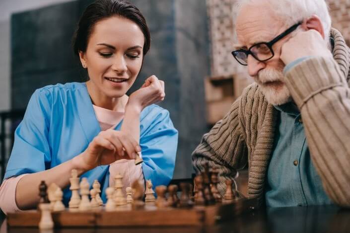 CNA with a Patient playing chess